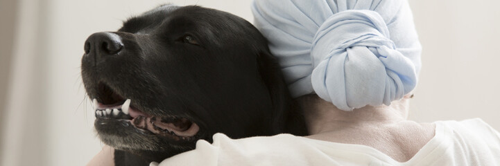 Sick person hugging black dog