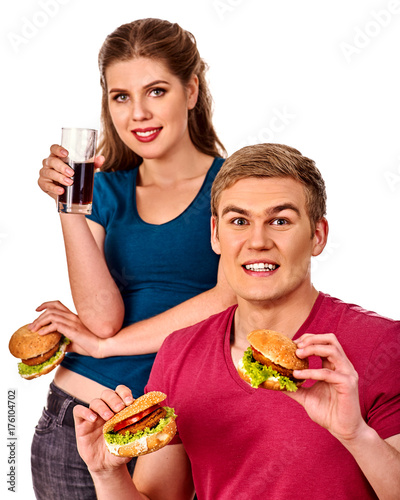 Couple eating fast food. Man and woman treat big hamburger with ham. Friends give burder junk on white background isolated. Food semi-finished products. How to feed husband. photo