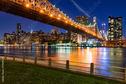 Evening view of Manhattan Midtown East from Roosevelt Island with the illuminated Ed Koch Queensboro Bridge and the East River. New York City