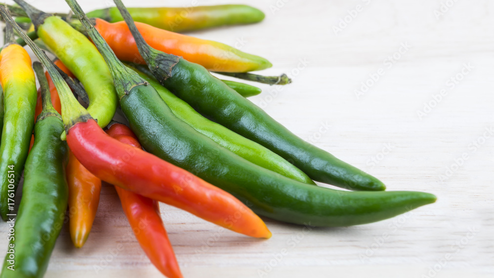 Hot Chilli Peppers isolated on wood board background, close up. Selective focus Hot Chilli Peppers isolated on wood board background, close up. Selective focus