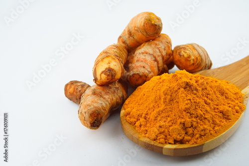 Turmeric powder and turmeric, bamboo ladle with isolated white background