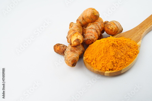 Turmeric powder and turmeric, bamboo ladle with isolated white background