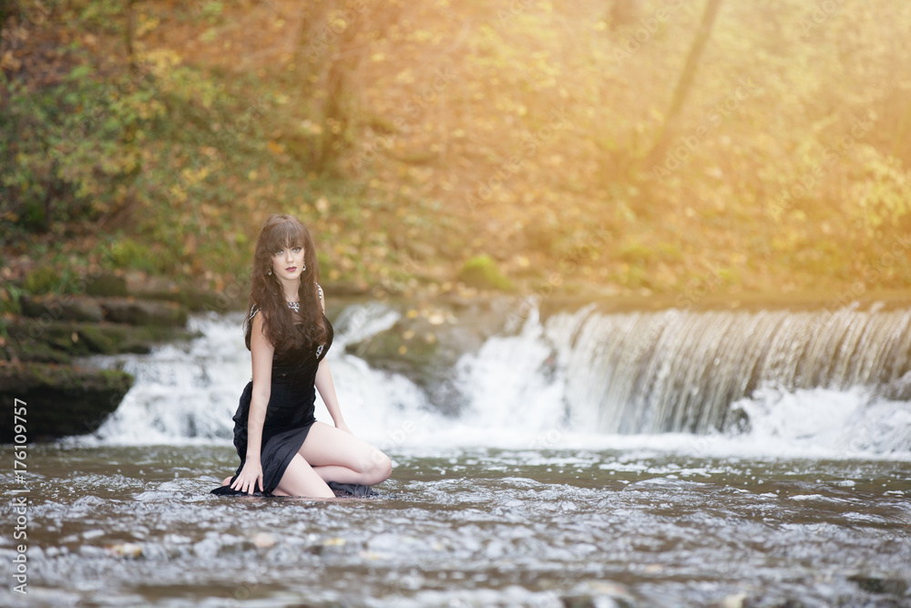 Brunette in a black dress in the water Brunette in a black dress in the water