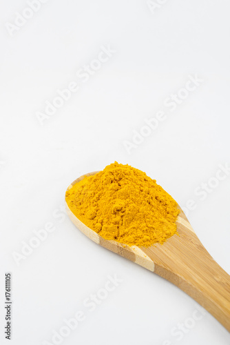 Turmeric powder and bamboo ladle with isolated white background