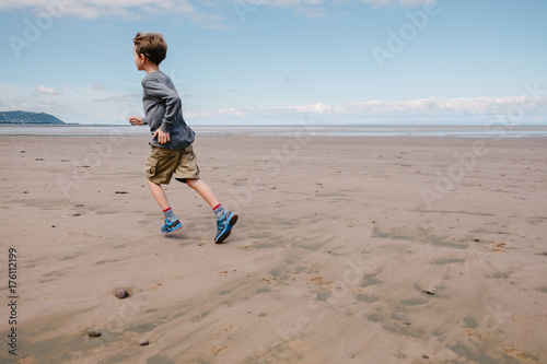 Child running on wet sand photo