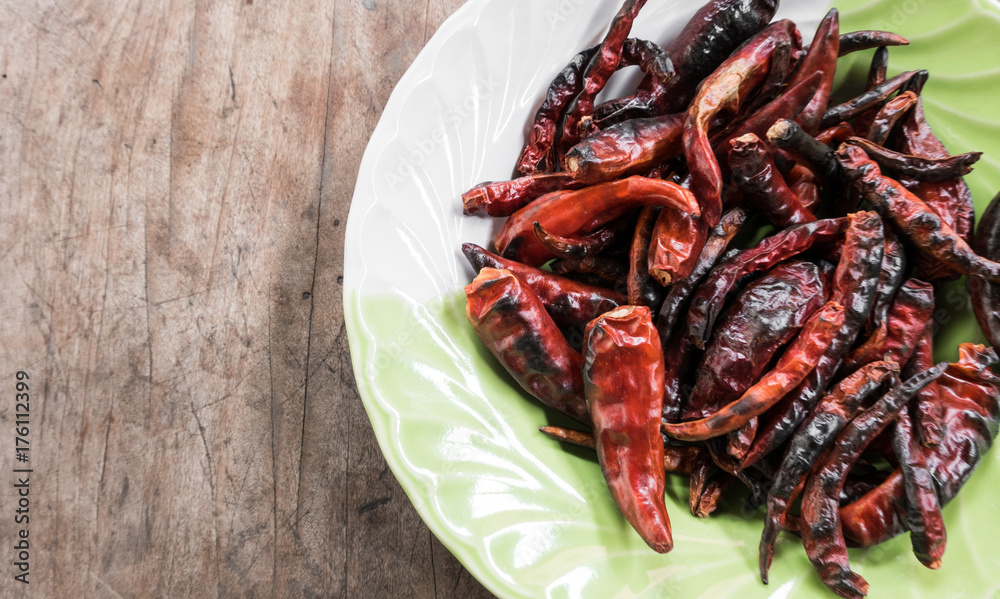 Red dried chillies for cooking Thai food in a dish on wood background
