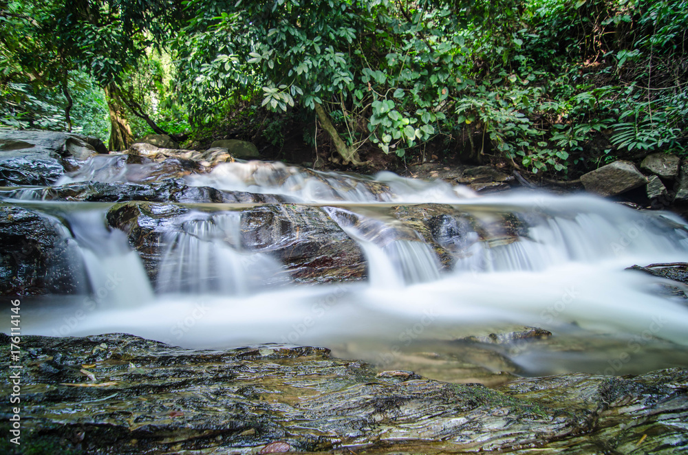 A small little waterfall falling on a small lake in Thailand