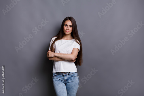 Cheerful girl in casual clothes posing at studio