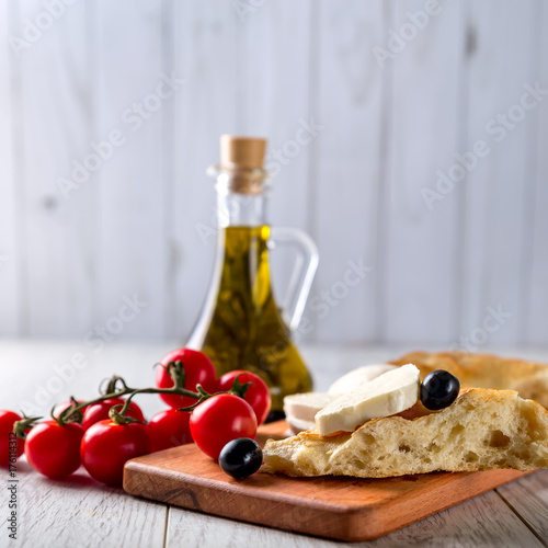 Olive oil, tomatoes, cheese and bread on the table