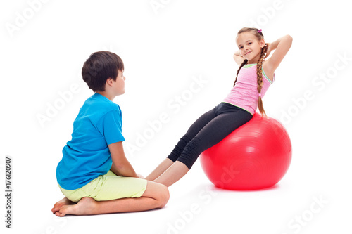 Kids exercising together using a large gymnastic rubber ball