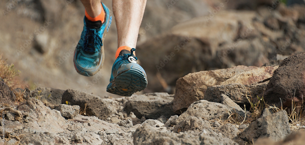 Athlete trail running in the mountains on rocky terrain, sports shoes  detail Stock Photo | Adobe Stock