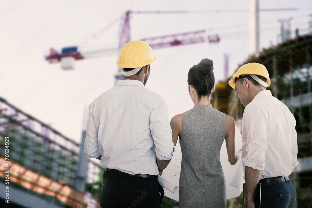 Composite image of rear view of architects discussing over Composite image of rear view of architects discussing over