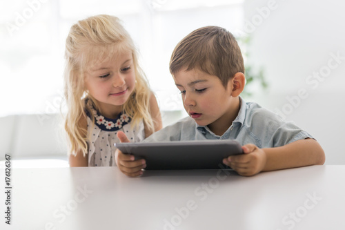 Adorable brother and sister young child using tablet