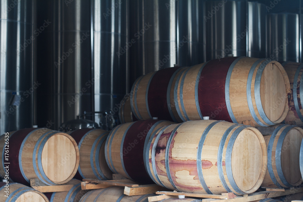 wine barrels next to chrome metallic tanks wine barrels next to chrome metallic tanks