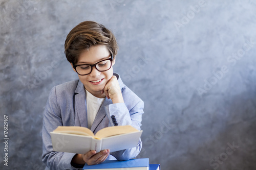 Cute teen boy reading book