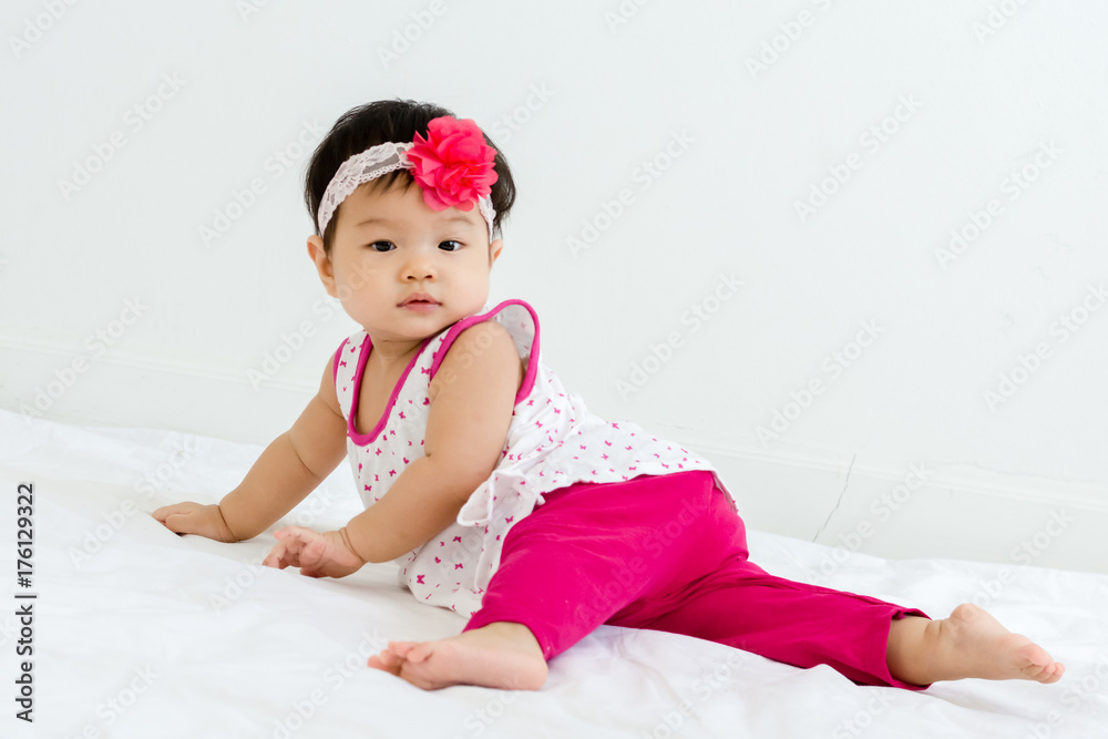 Portrait of adorable baby sliding on a sloped floor with head band Portrait of adorable baby sliding on a sloped floor with head band