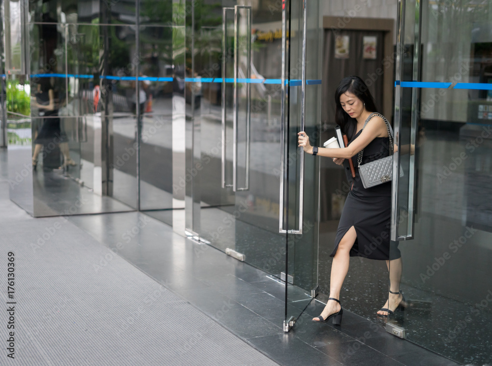 Business woman is walking through the front door of her office with a  document file Stock Photo | Adobe Stock