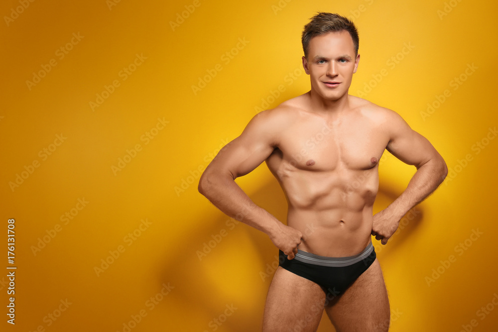 Fototapeta premium Muscular man in underwear on color background