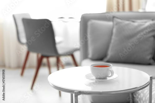 Table with cup of tea in beautiful living room