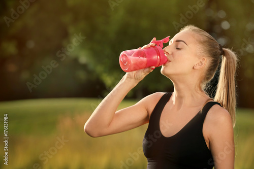 Sporty young woman drinking...
