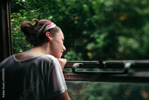 Young woman looking through open railroad car window