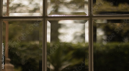 Macro  glass door in vintage style. In background  there is a blurred green view of nature.