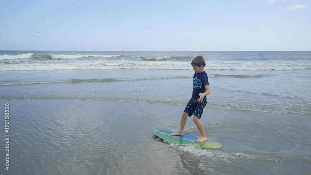 Little boy skim boarding at Myrtle Beach durning summer vacation Stock