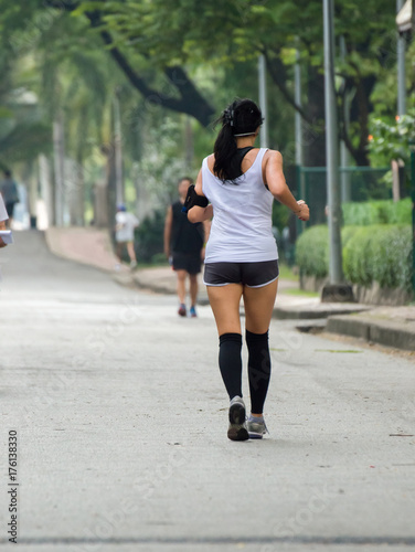 Back view of jogging girl in park