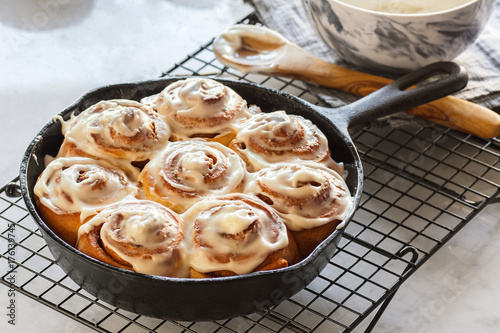 Iced Cinnamon Rolls or Buns Baked in Cast Iron Skillet on Cooling Rack