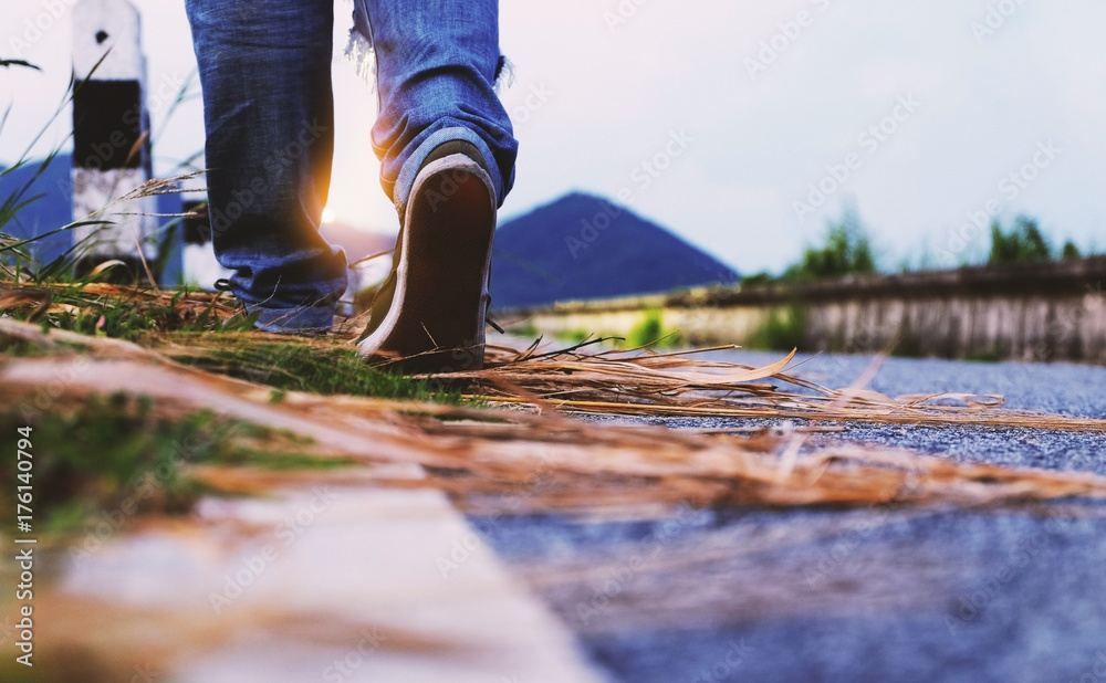 Woman wear jeans and sneaker shoes walk on the road Woman wear jeans and sneaker shoes walk on the road