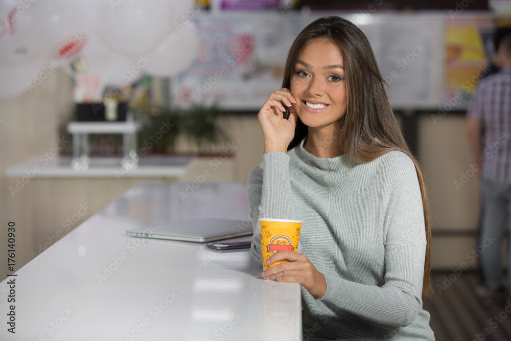 Portrait of a beautiful woman, sitting in cafe and drink coffee Portrait of a beautiful woman, sitting in cafe and drink coffee