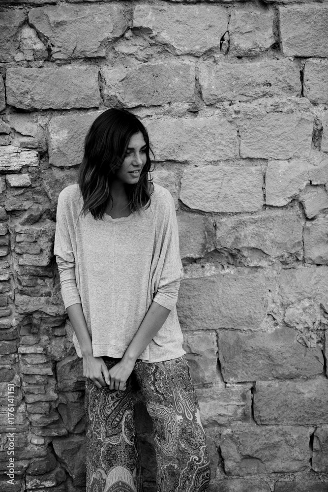 stylish brunette woman against stone wall stylish brunette woman against stone wall