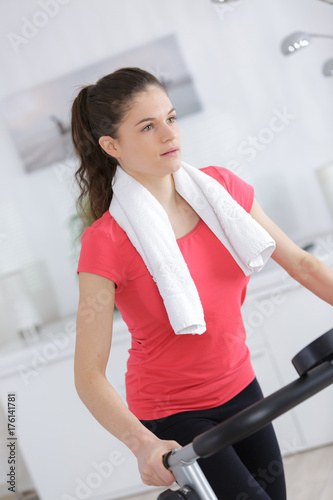 sporty woman training on exercise bike in the living room