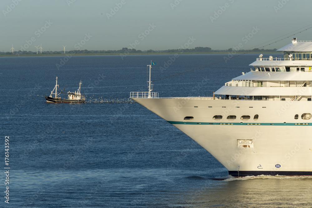 Bug eines Kreuzfahrtschiffes und Krabbenkutter auf der Weser vor Bremerhaven, Deutschland