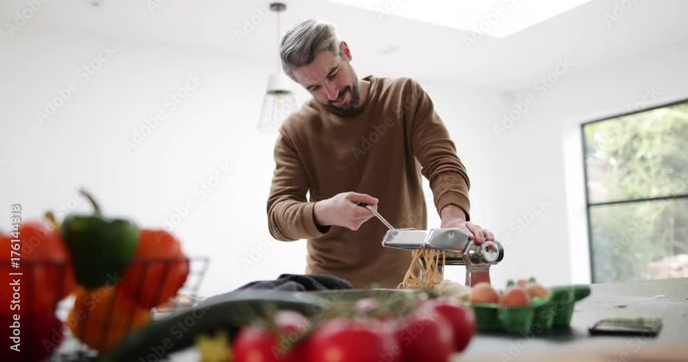 Adult male using a pasta machine Adult male using a pasta machine