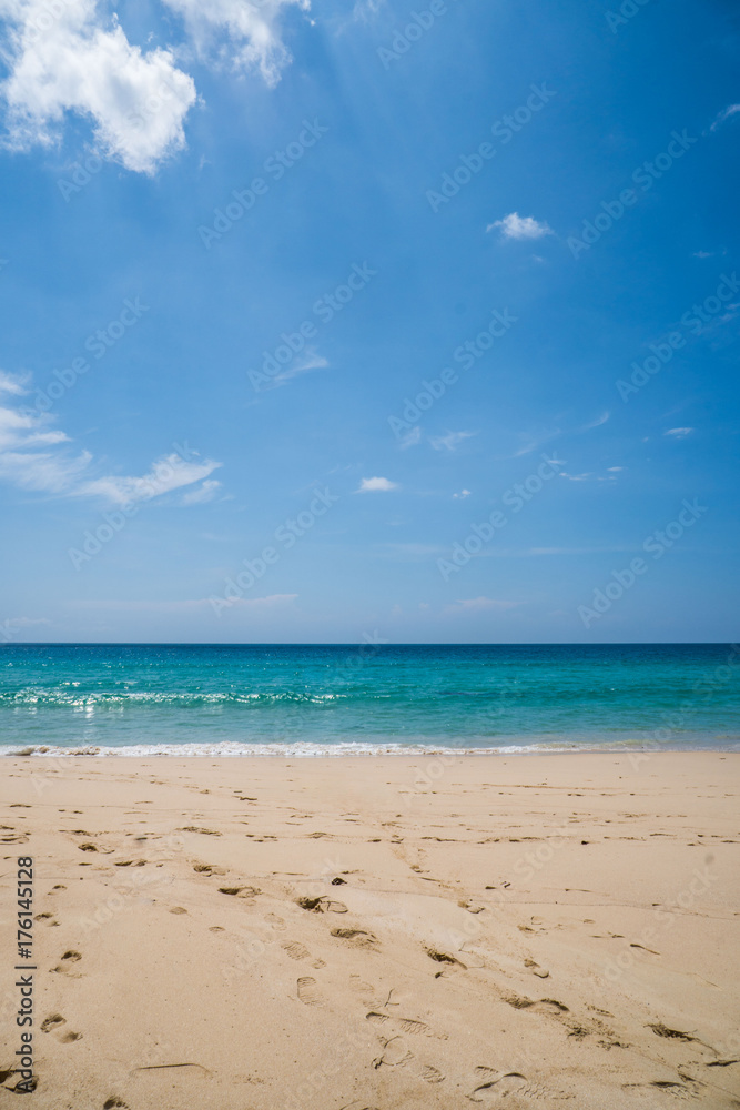 Beautiful tropical sandy beach over blue sea and sky background