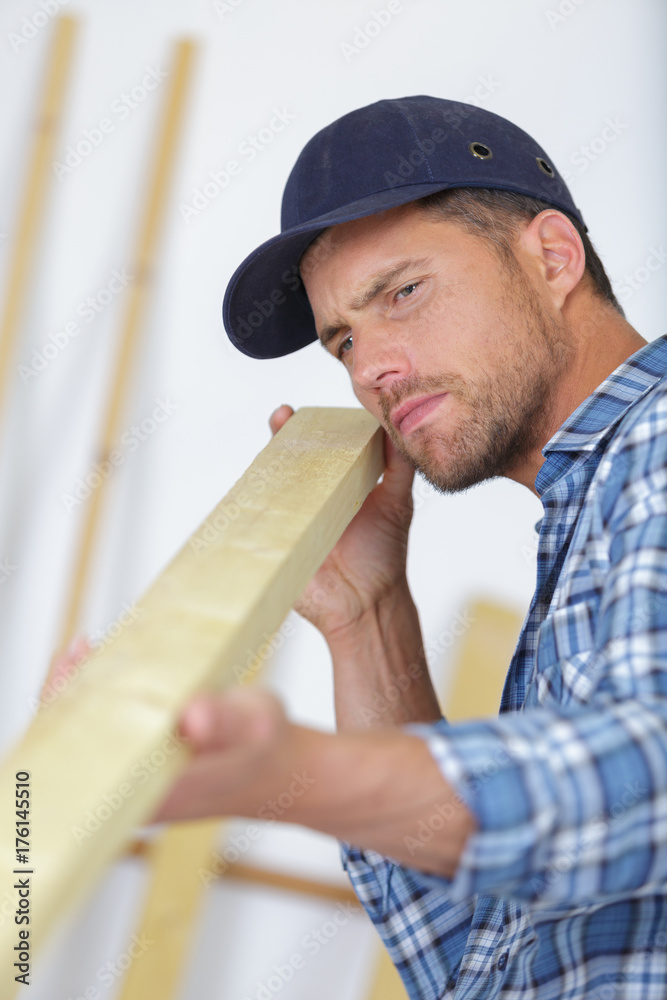 concentrated young male carpenter checking board concentrated young male carpenter checking board