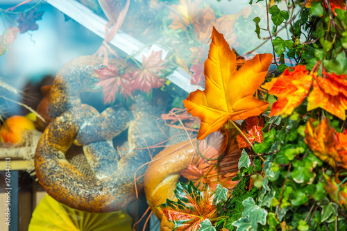 Artificial maple leaf on the background of a showcase with bread. Colorful autumn in Moscow city, Russia.