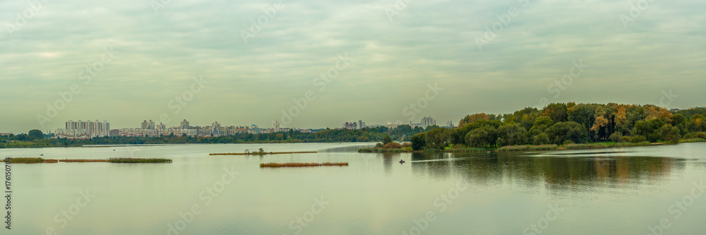 panoramic view of a large urban reservoir with an island and a modern residential area on the opposite coast