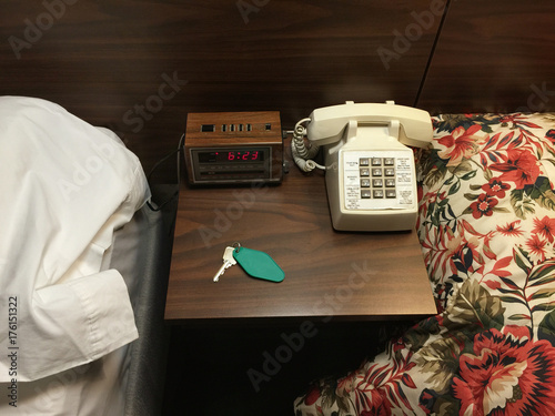 Still life in 60s era motel room featuring phone, clock radio and key photo