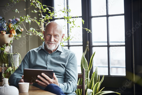 Happy Senior Man Using Digital Tablet At Home