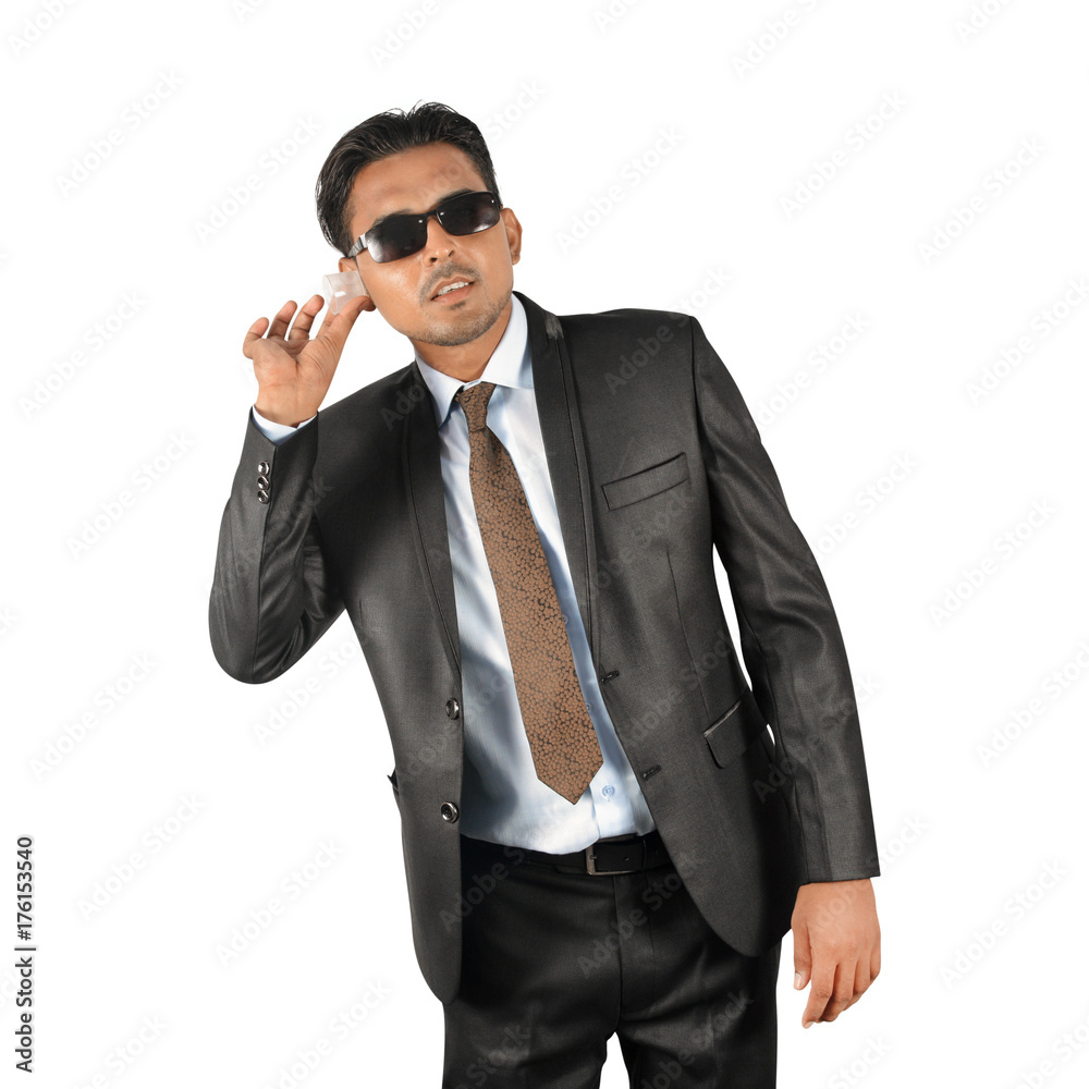 Businessman in black suit trying to hear over white background Businessman in black suit trying to hear over white background
