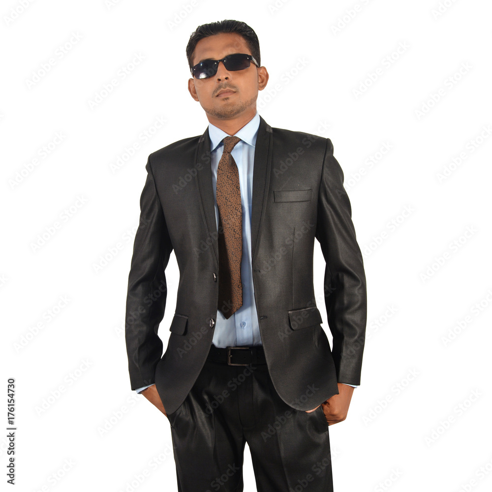 Portrait of a young businessman in black suit, hands in pocket over white background Portrait of a young businessman in black suit, hands in pocket over white background