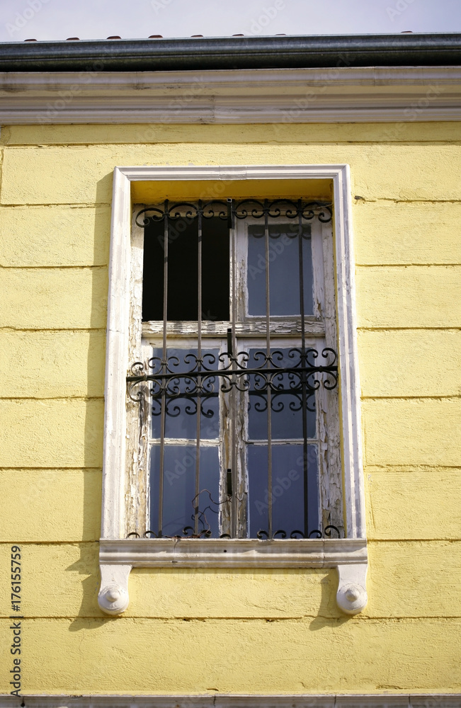 Obraz premium Old window on a yellow facade.