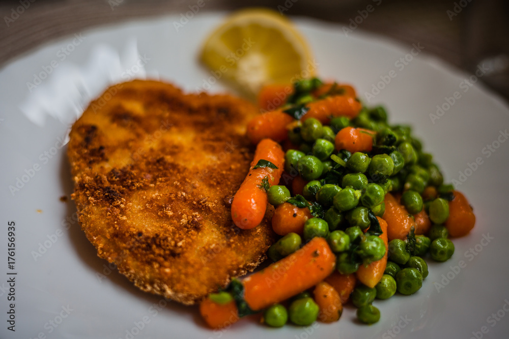 Plate of cotoletta with carrots and peas Plate of cotoletta with carrots and peas