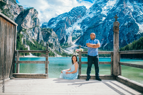  Man and woman on vacation in beautiful place mountains.Young couple in love on the pier at lake, lago di braies,Dolomite,Italy.