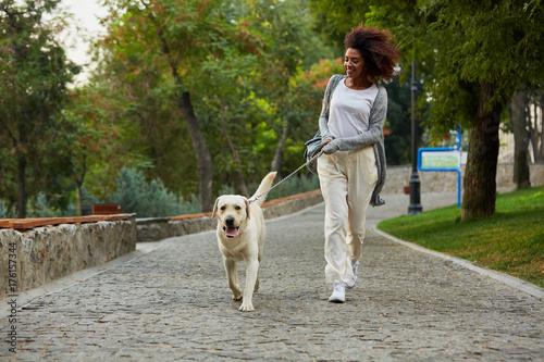 Funny healthy lady running in the morning with her dog in park photo