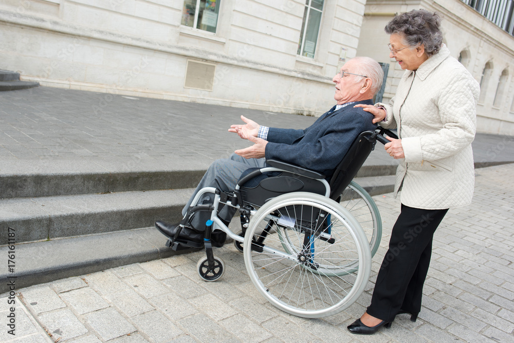 old woman woman pushes husband in wheelchair old woman woman pushes husband in wheelchair