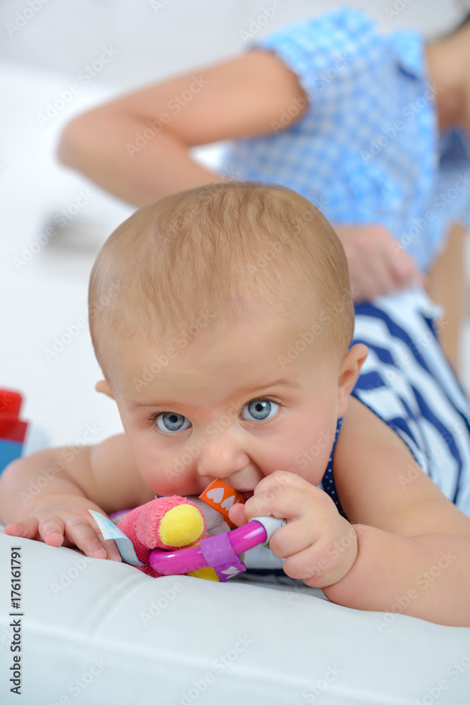 small newborn baby schewing on a plastic rattle small newborn baby schewing on a plastic rattle