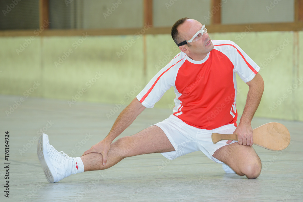 man doing sport exercises in indoor tennis court
